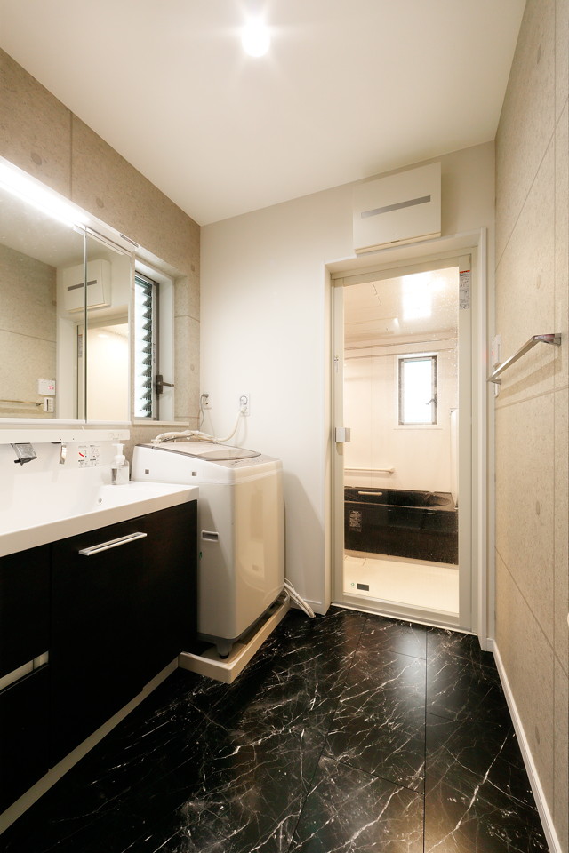 洗面室もブラックを基調にかっこいいバスルーム。収納もしっかり確保し見た目はスッキリと。